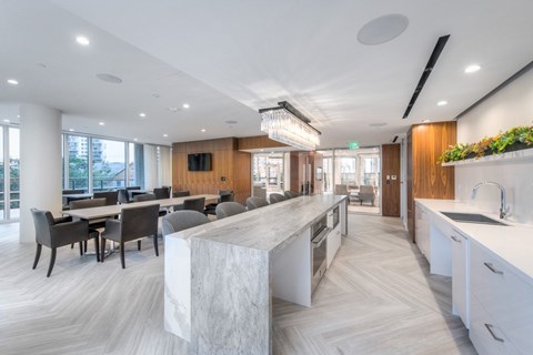 A modern kitchen with a marble island and wooden accents.