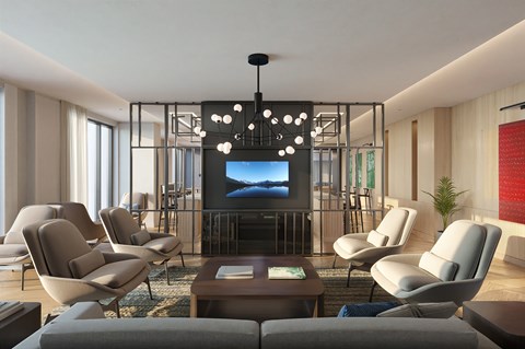 A modern living room with a large screen TV and comfortable seating.