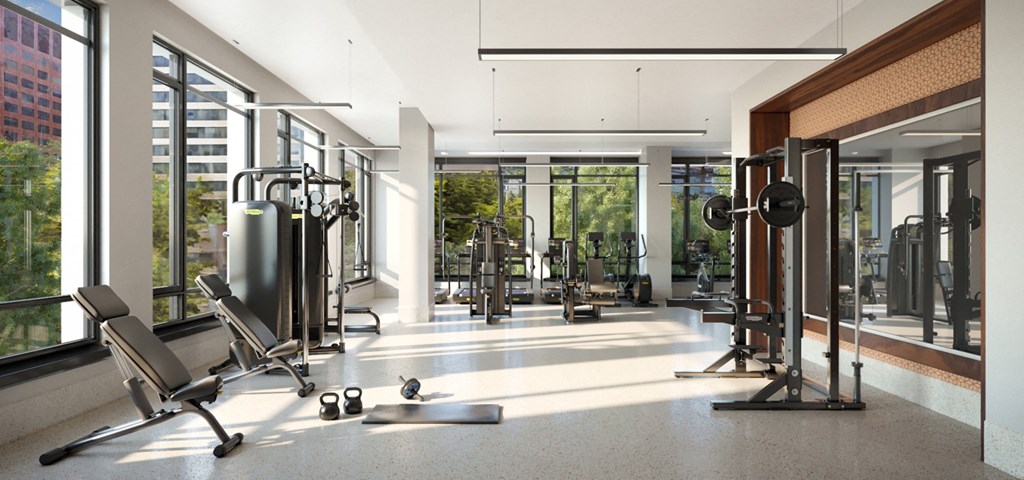 a gym with a lot of exercise equipment and large windows