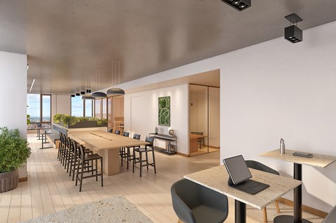 A modern office space with a long table, chairs, and a laptop on a table.