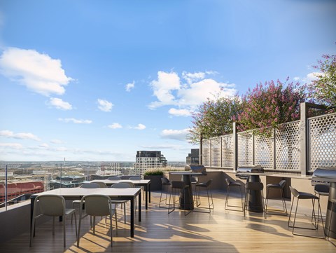 A patio with a table and chairs overlooking a cityscape.