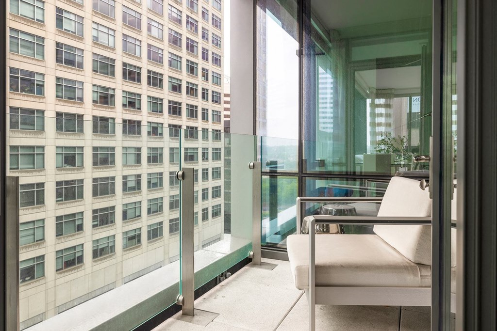 a room with a view of a skyscraper and a chair