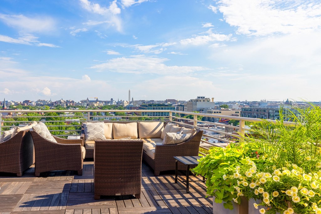a roof deck with couches and chairs and a view of the city