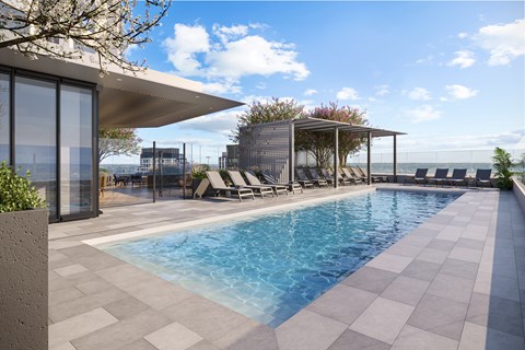 A modern pool area with a glass wall and a sun lounger.