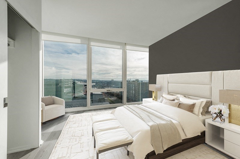 a bedroom with a large bed and a view of the city