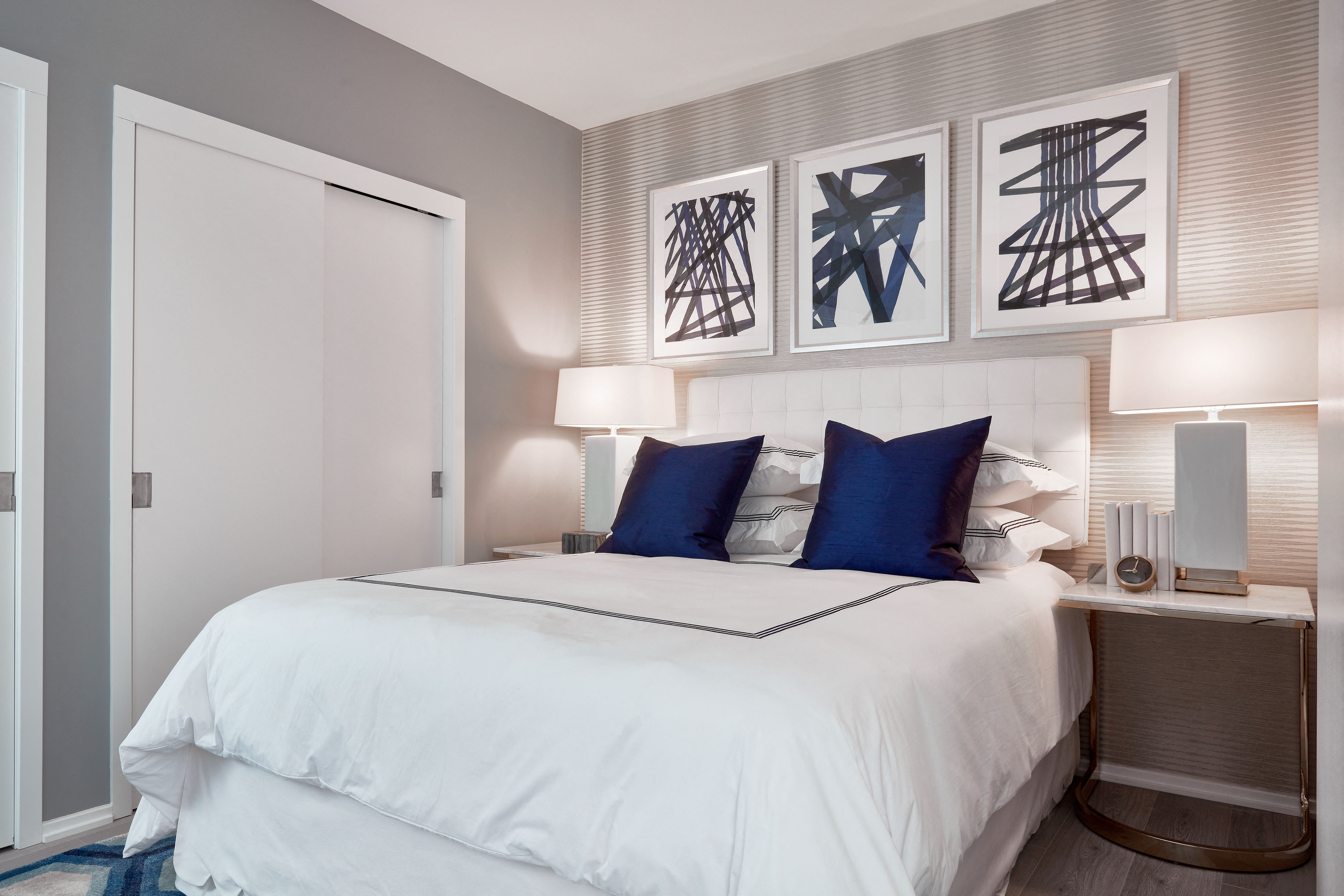 a bedroom with a white bed and blue pillows