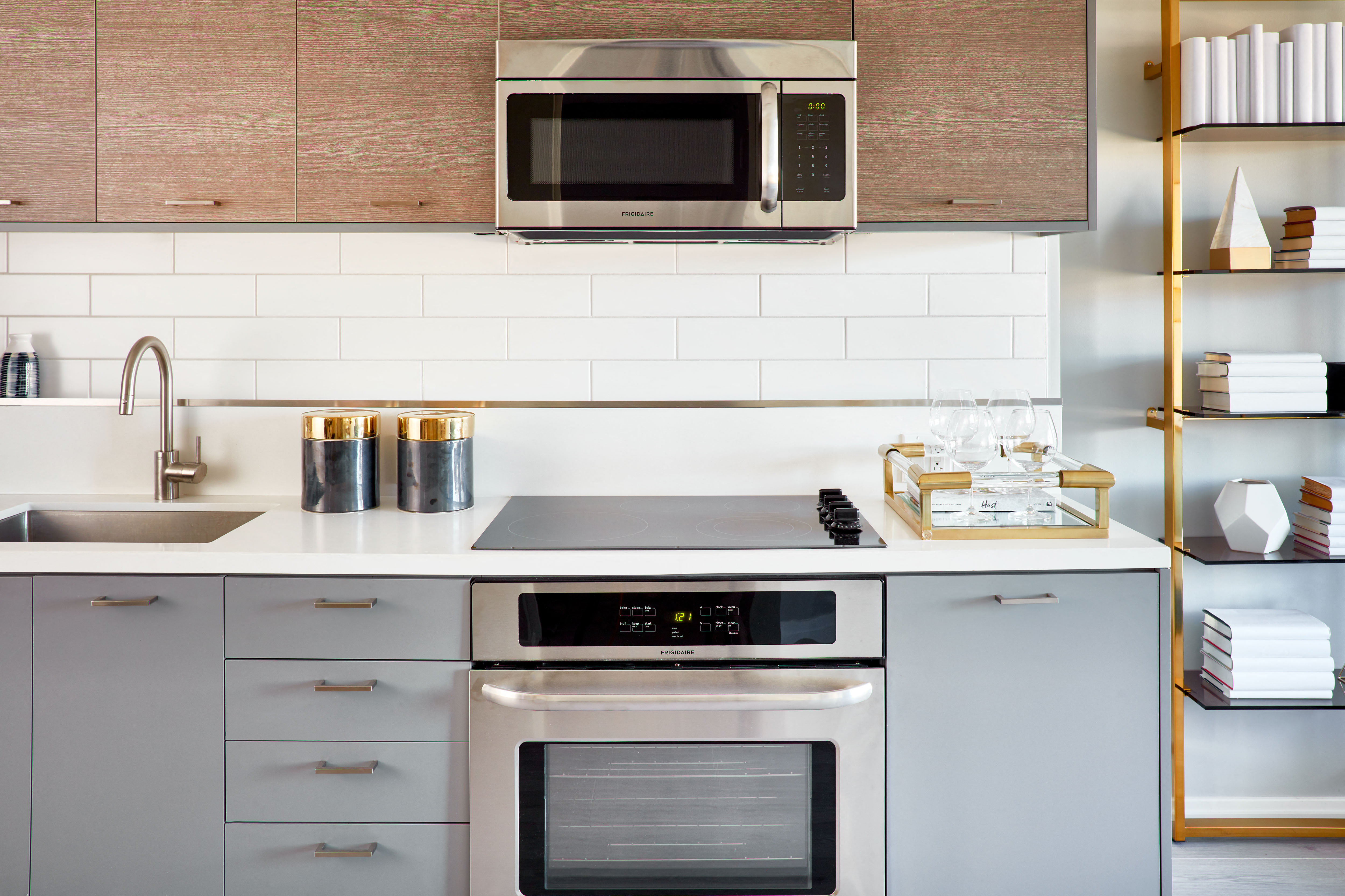 a kitchen with white cabinets and a stainless steel oven and microwave