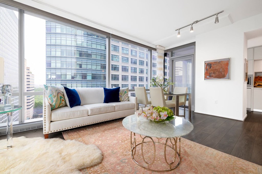 a living room with a couch and a table in front of a window