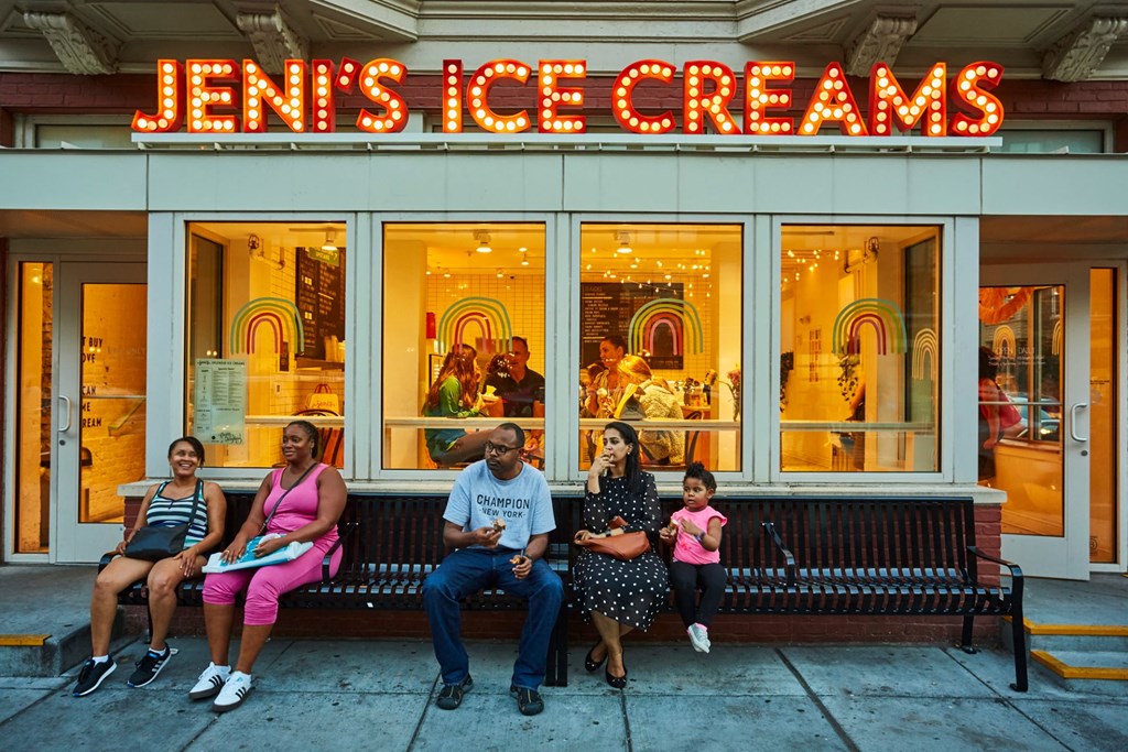a group of people sitting on a bench outside of a store