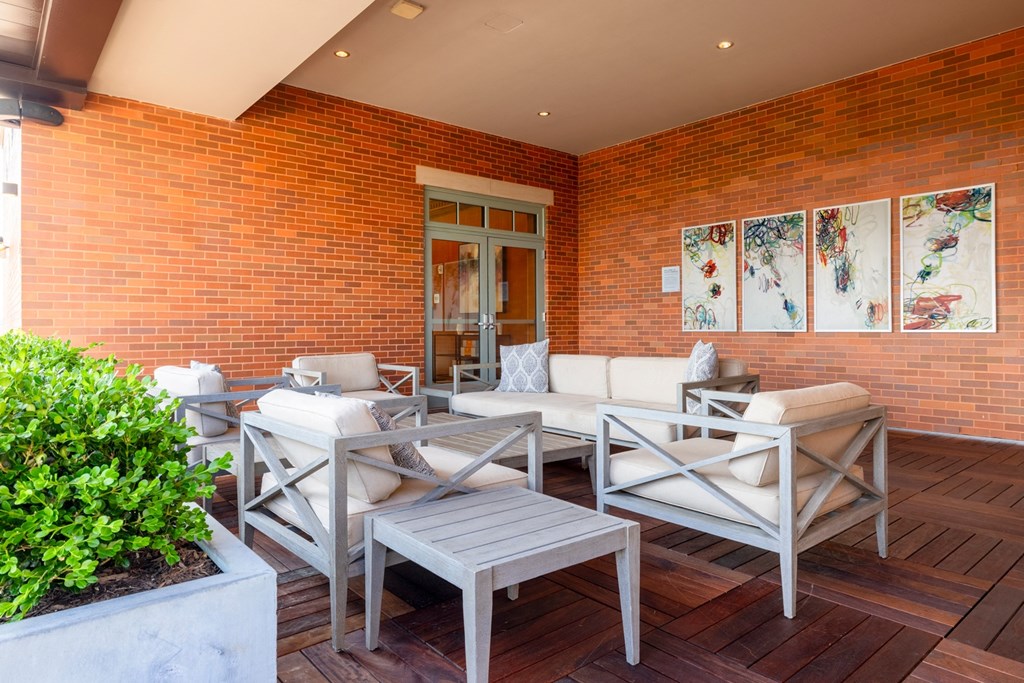 a patio with white furniture and a brick wall