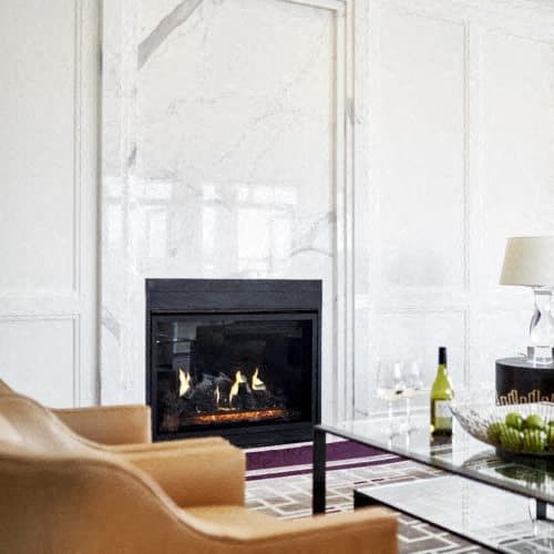 a living room with chairs and a fireplace