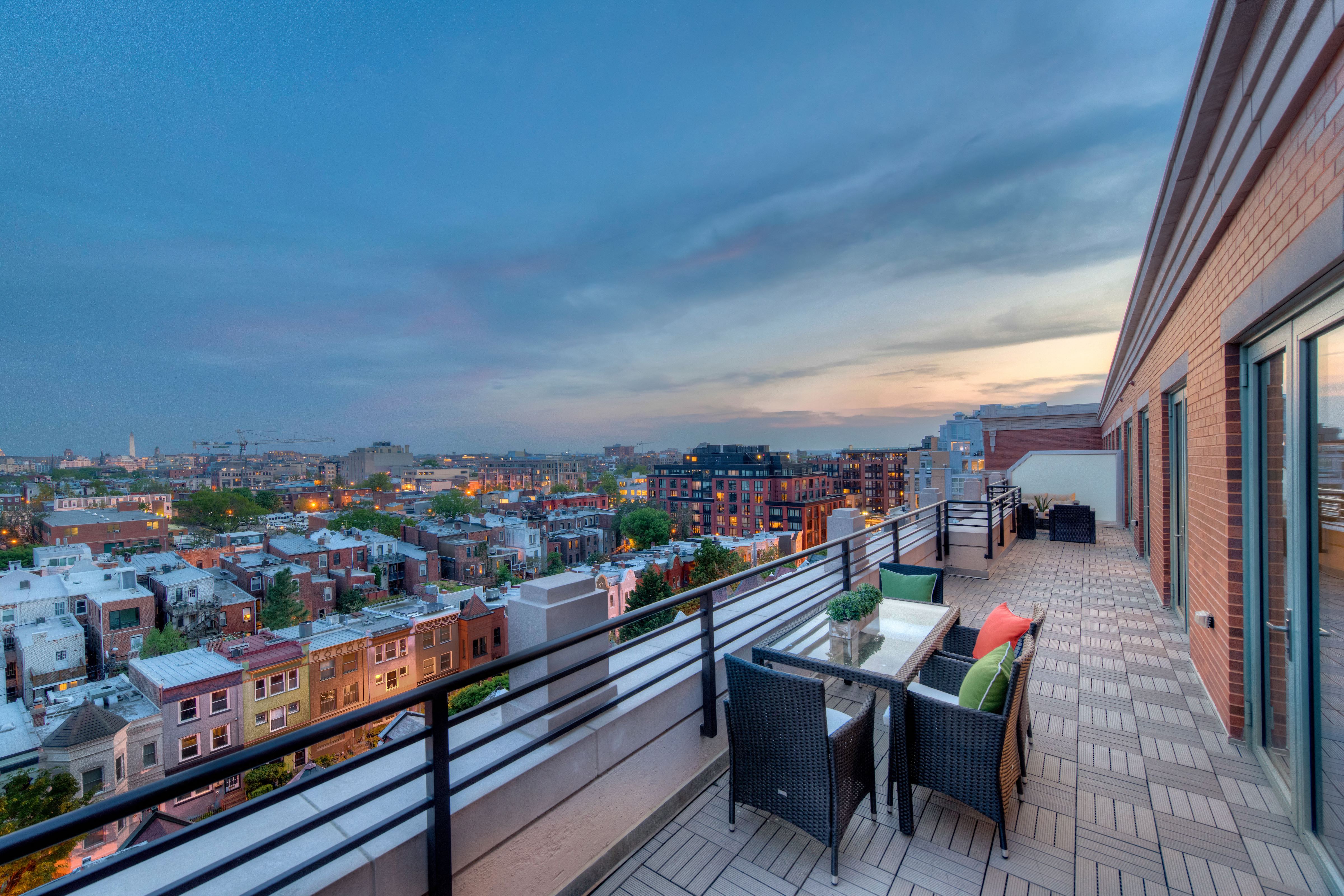 a balcony with a view of a city and a sunset