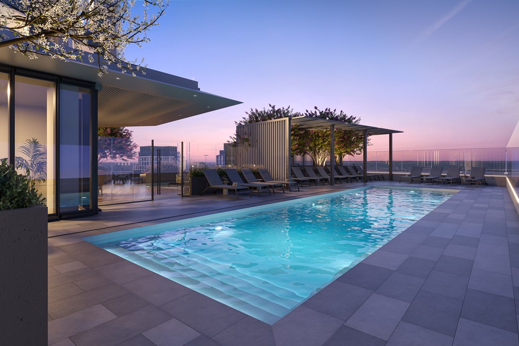 A modern pool area with a sun lounger and a tree.