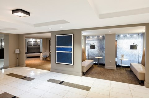 a lobby of a hotel with a reception area and a living room