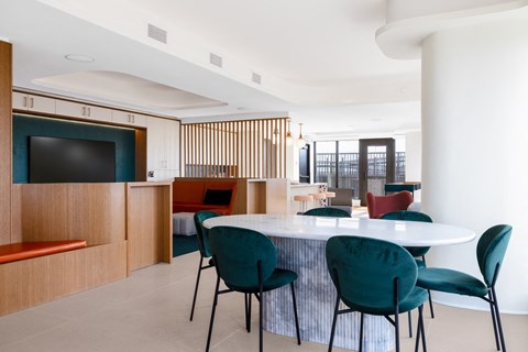a dining room with a white table and green chairs