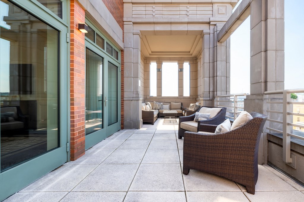 a patio with chairs and couches on a balcony