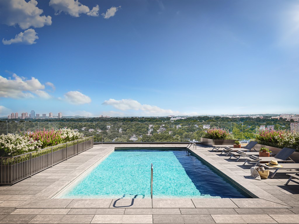 a swimming pool on a roof with a city in the background