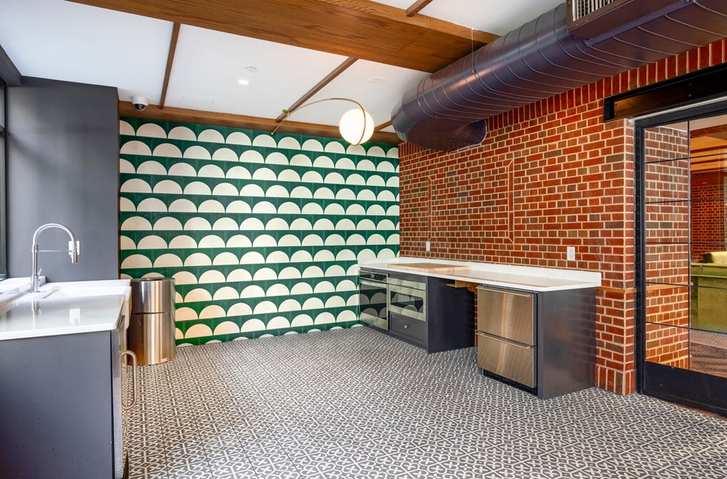 a kitchen with green and white wallpaper and stainless steel appliances