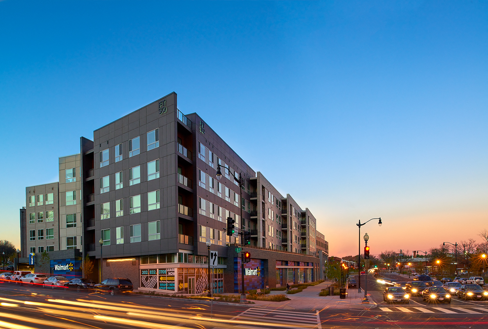 a large building on the corner of a city street at sunset