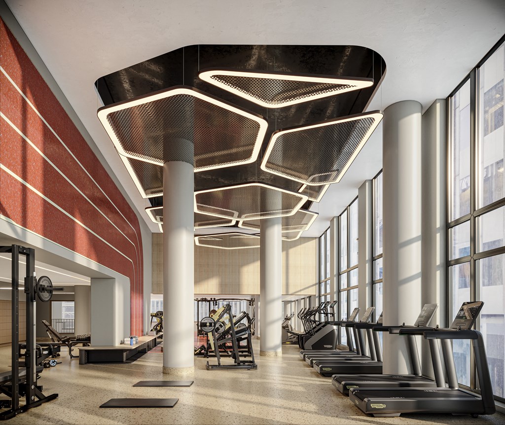 a gym with cardio machines and large windows