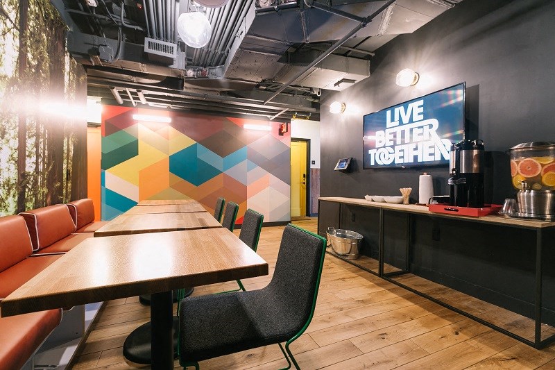 a dining room with tables and chairs and a wall with a sign that reads live