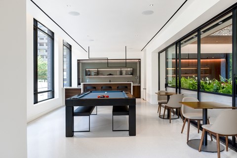 a black pool table in the center of a room with tables and chairs at The Grace and Reva, Virginia, 22202