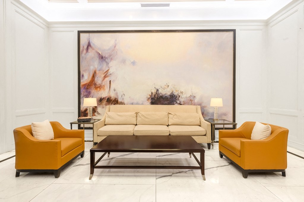 a living room with a large painting on the wall behind the couch