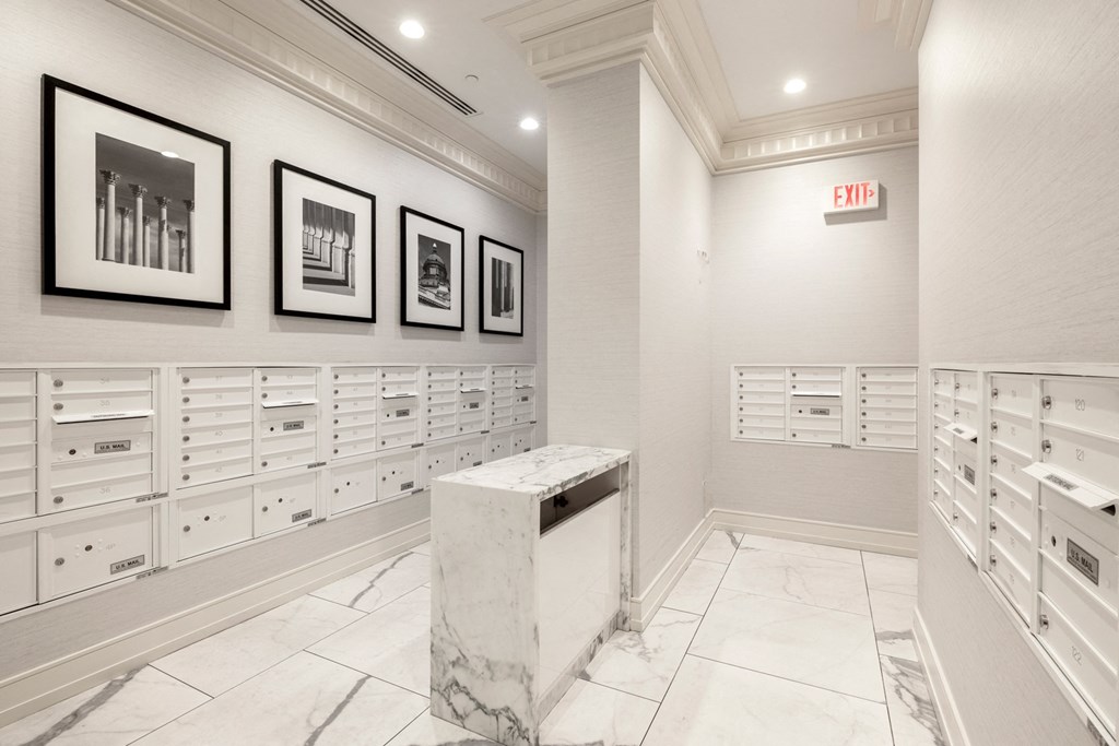 a mail room with white cabinets and a marble podium