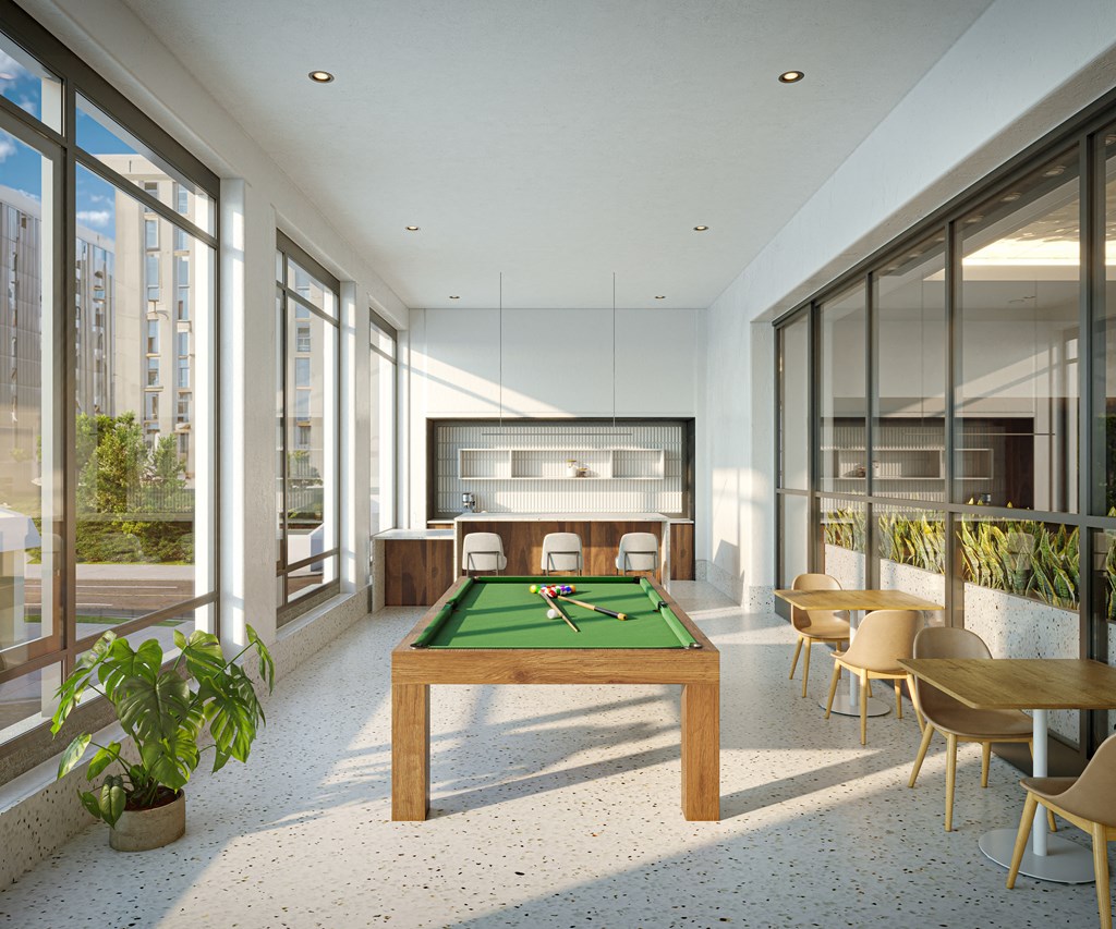 a living room with a pool table and chairs