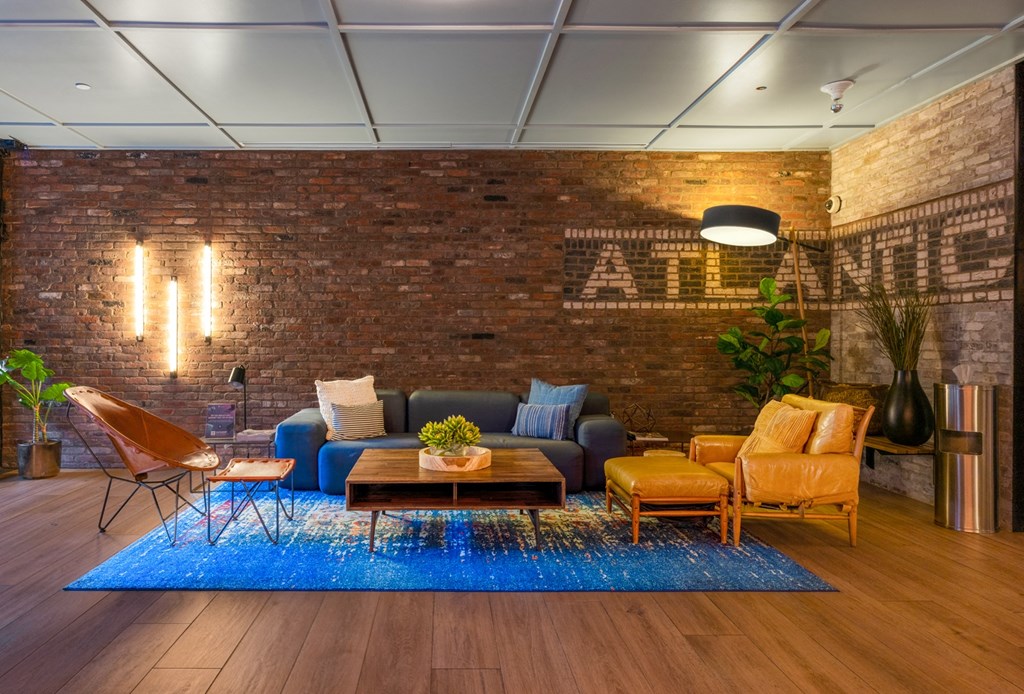 a living room with a brick wall and a blue rug