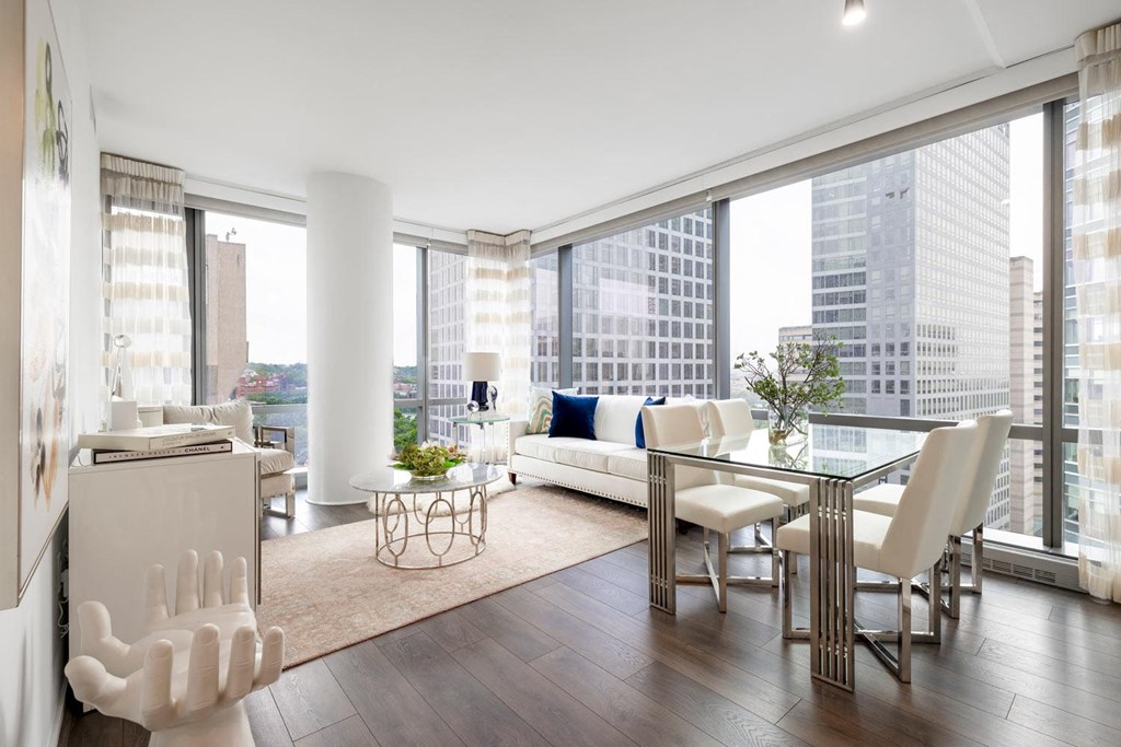 a living room with a large window and a table with chairs