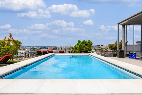 the pool on the roof of a building with a city in the background