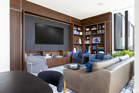 A living room with a brown sofa and a black television.