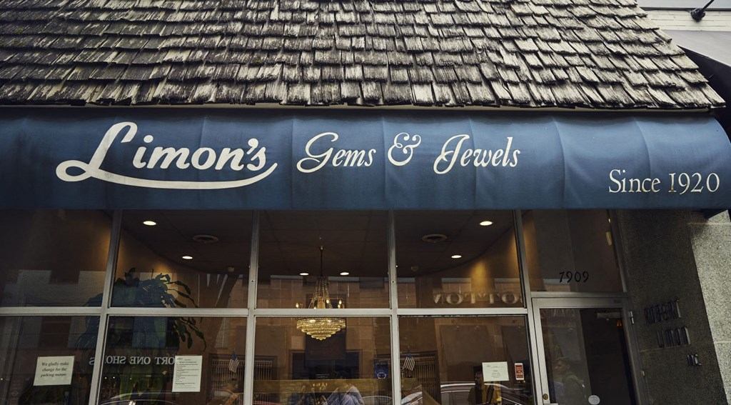 a store front with a blue awning and the wordslimons jeans and