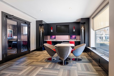 a dining room with a table and chairs and a tv on the wall