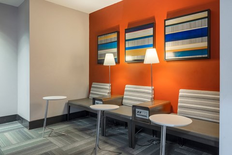 a waiting room with four tables and chairs and three lamps