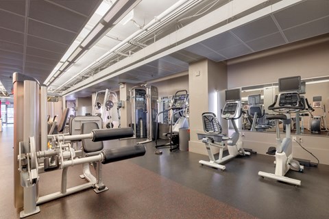 a gym with various machines and weights in a building