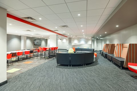 a lounge area in a large room with chairs and couches