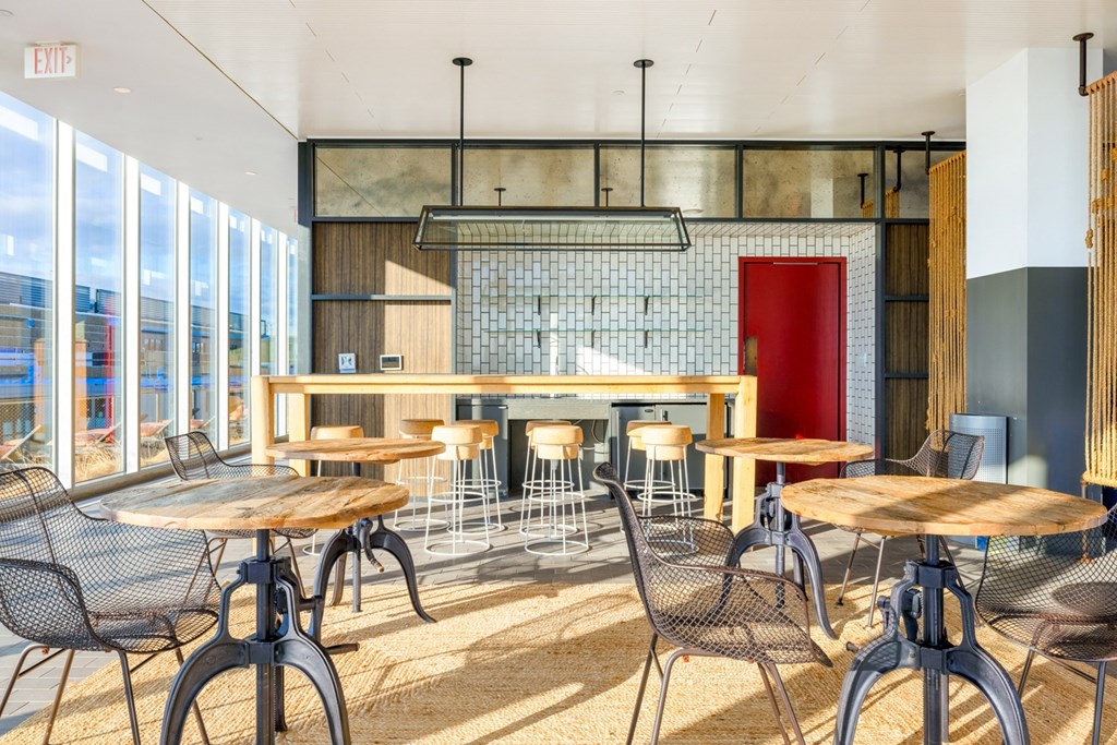 a restaurant with wooden tables and chairs and a bar with red door