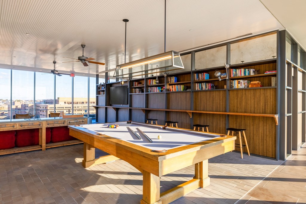 a games room with a pool table and a tv