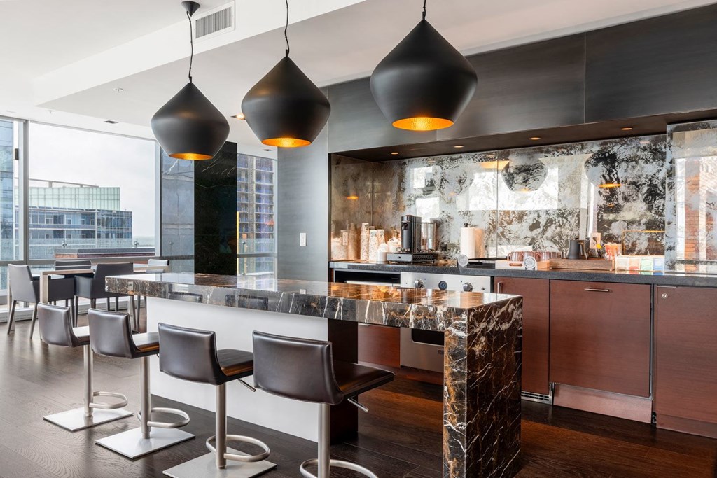 a kitchen with a marble counter top and chairs