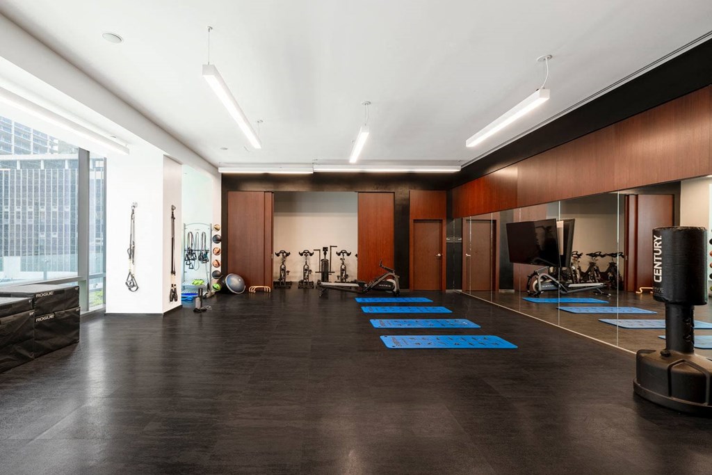 a workout room with weights and cardio equipment in a large room