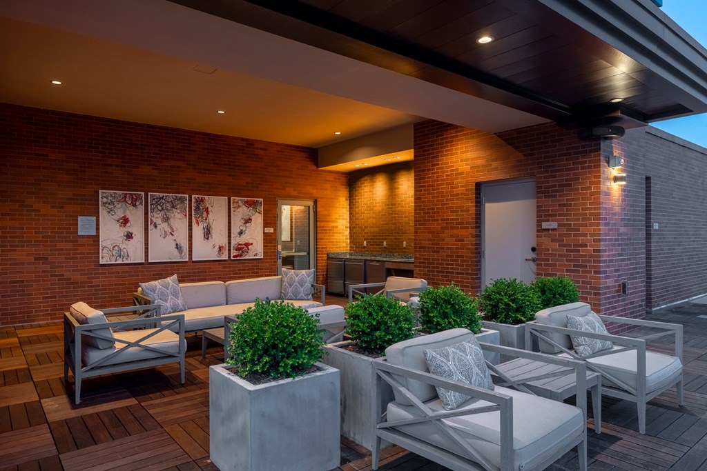 a patio with a couch and chairs and a sink in the background