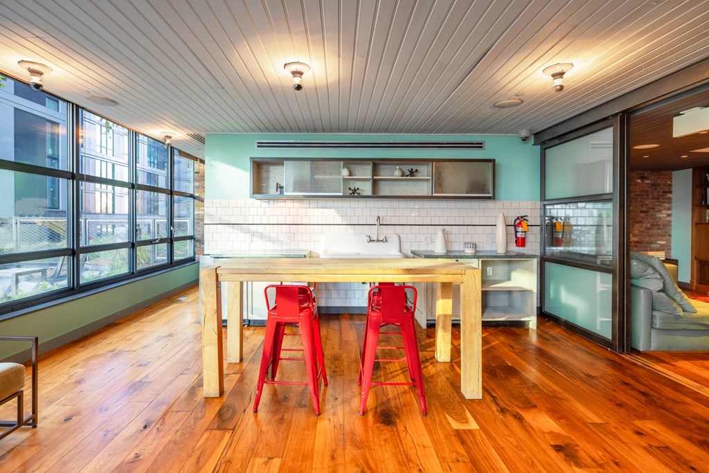a kitchen with a wooden table and red chairs