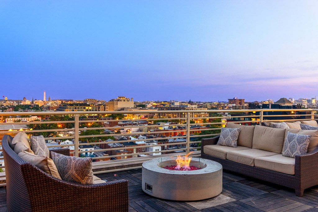 a patio with a firepit and two couches on a wooden deck with a view of