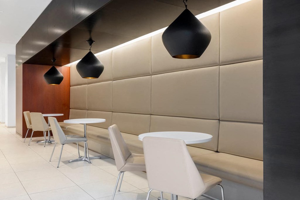 a restaurant with white tables and chairs and lights on the ceiling