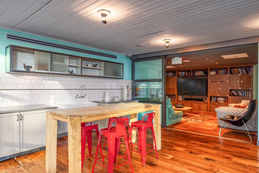 a kitchen with a wooden table and red chairs
