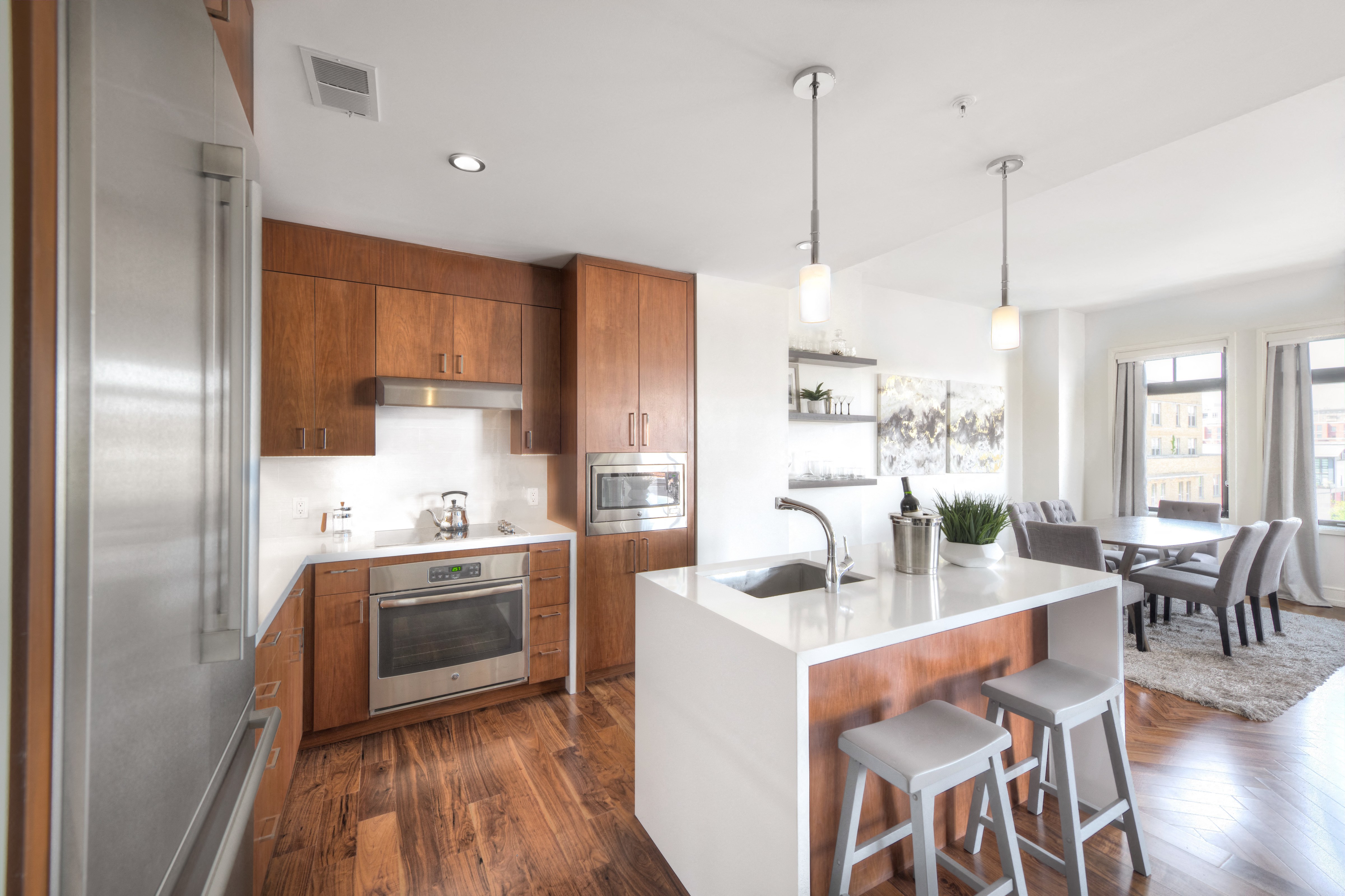 a kitchen with wooden cabinets and a white island with stools