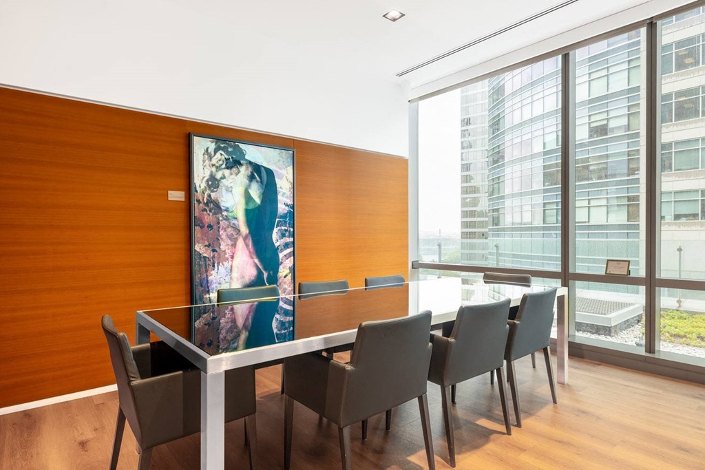 a conference room with a table and chairs and a painting on the wall
