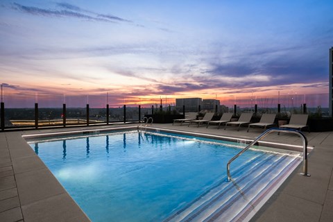 a swimming pool on the rooftop of a building at sunset
